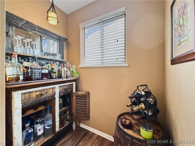 bar featuring wood finished floors and baseboards