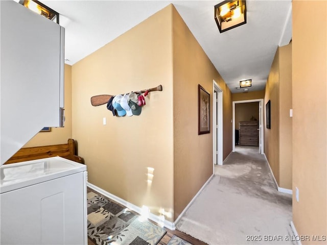 hallway featuring washer / dryer and baseboards