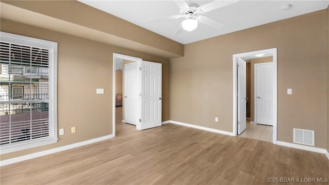 unfurnished bedroom featuring light wood-type flooring, baseboards, and visible vents