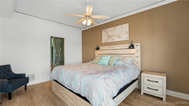 bedroom featuring crown molding, wood finished floors, visible vents, and baseboards