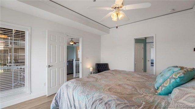 bedroom featuring ornamental molding, wood finished floors, and a ceiling fan