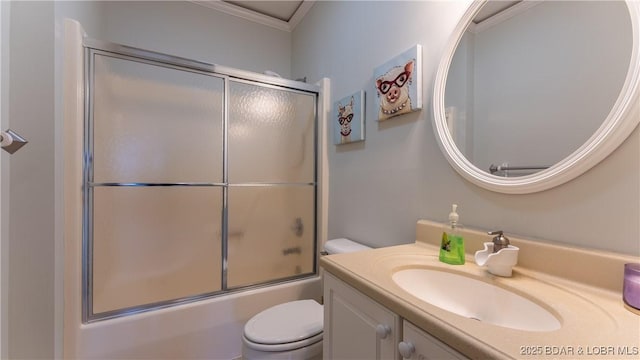 bathroom with crown molding, shower / bath combination with glass door, vanity, and toilet