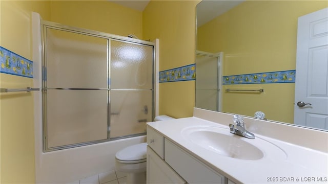 bathroom featuring tile patterned flooring, shower / bath combination with glass door, vanity, and toilet