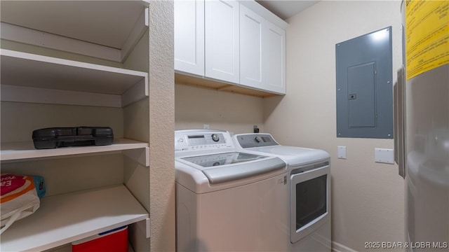 washroom with cabinet space, electric panel, and washer and dryer