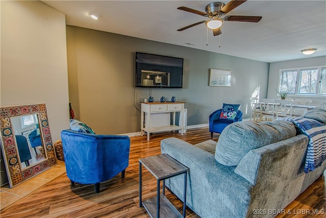 living room featuring ceiling fan, wood finished floors, and baseboards