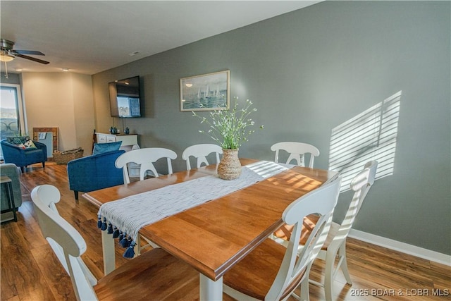 dining area with ceiling fan, baseboards, and wood finished floors