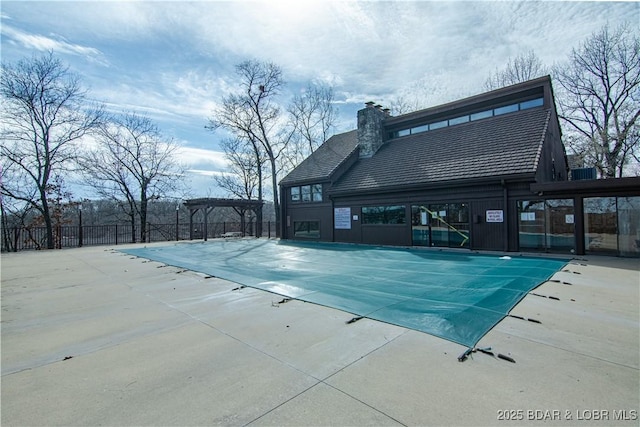 community pool featuring fence, a pergola, and a patio