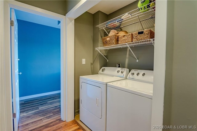 clothes washing area featuring laundry area, baseboards, light wood-style floors, and washer and dryer