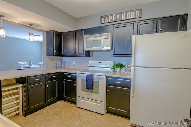 kitchen with pendant lighting, white appliances, light countertops, and light tile patterned floors