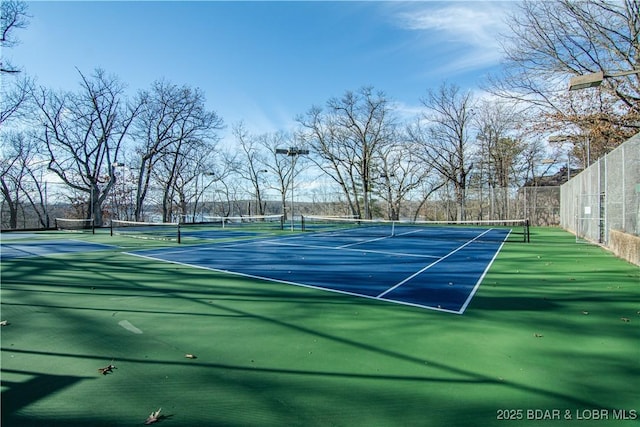 view of tennis court featuring fence