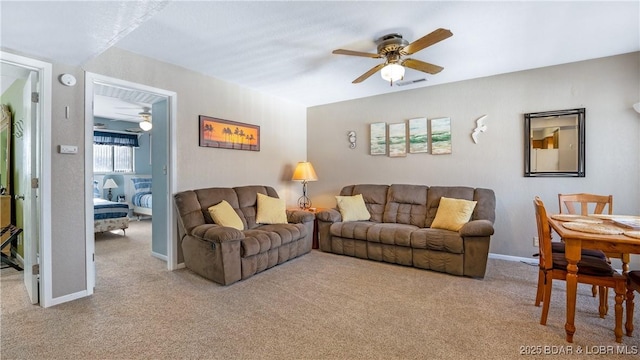 living room featuring visible vents, carpet floors, a ceiling fan, and baseboards