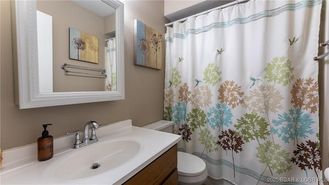 bathroom with toilet, a shower with shower curtain, and vanity