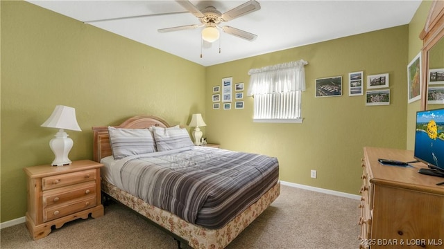 carpeted bedroom with a ceiling fan and baseboards