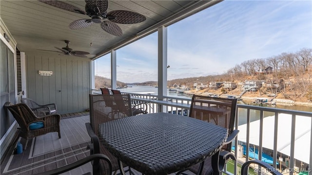 balcony with a water view and a ceiling fan