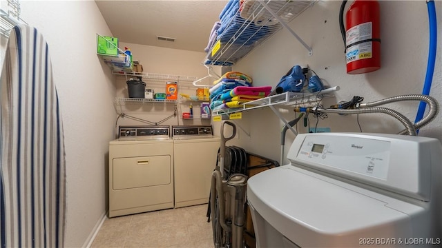 clothes washing area featuring washer and dryer, laundry area, and visible vents