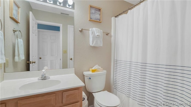 bathroom featuring visible vents, a textured wall, toilet, vanity, and a shower with curtain