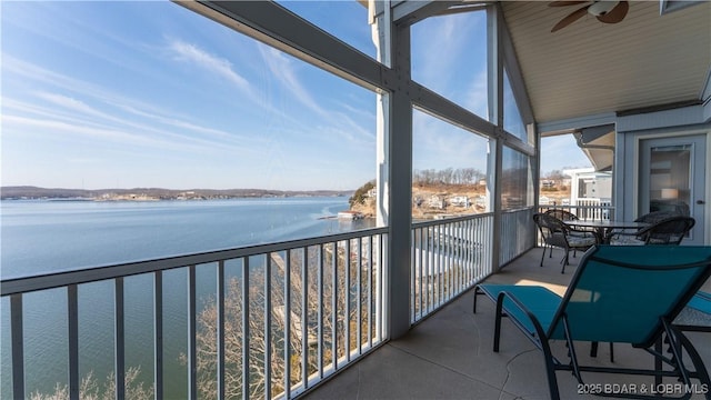 balcony with a water view and a ceiling fan