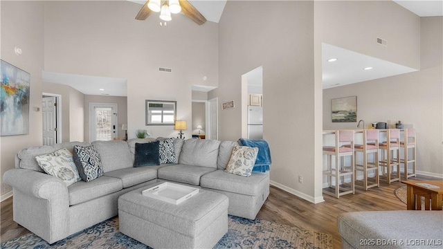 living area with visible vents, baseboards, and wood finished floors