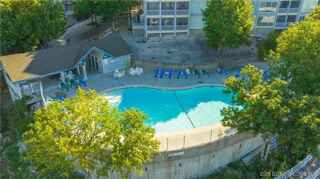 view of swimming pool featuring a fenced in pool, a patio area, fence, and stairs