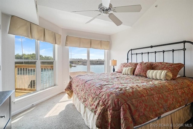 bedroom featuring ceiling fan, a water view, carpet flooring, and baseboards