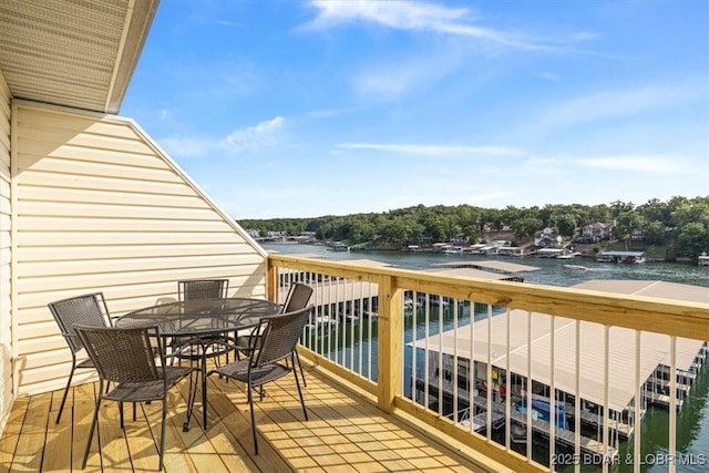 balcony featuring outdoor dining space and a water view