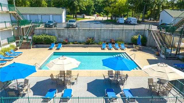 pool featuring stairway, a patio area, and fence