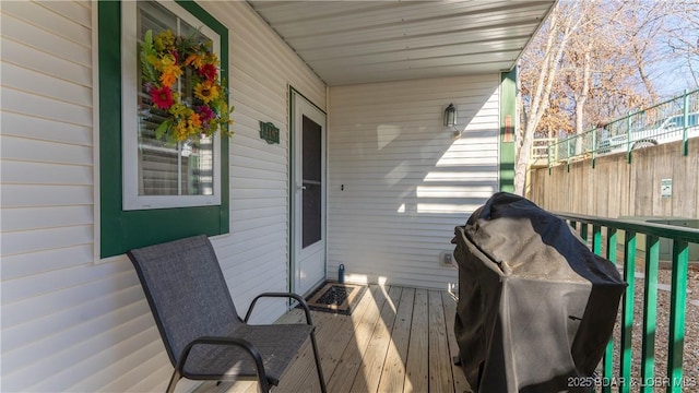 wooden terrace featuring area for grilling and fence