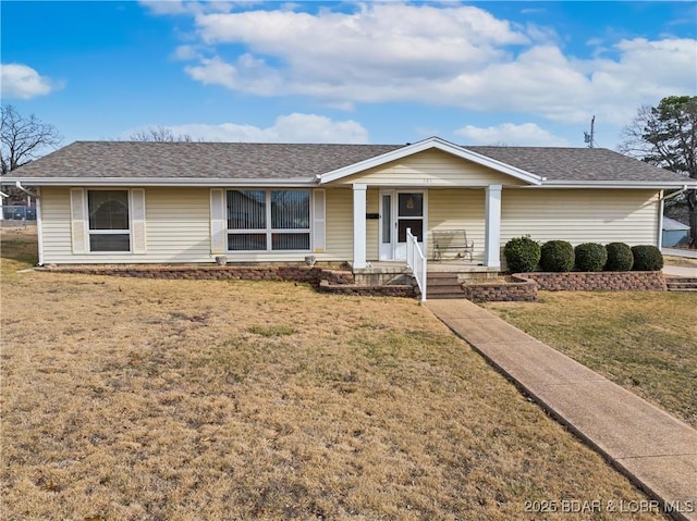 ranch-style home with covered porch, a front lawn, and a shingled roof