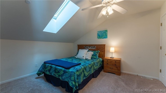 bedroom with a ceiling fan, carpet, vaulted ceiling with skylight, and baseboards