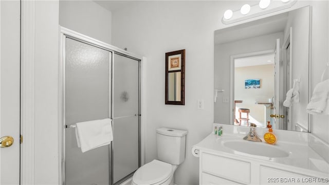 bathroom featuring a stall shower, vanity, and toilet