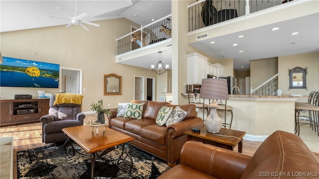 living area featuring visible vents, a high ceiling, light wood-style floors, a notable chandelier, and recessed lighting