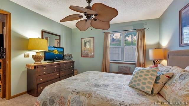 bedroom featuring a textured ceiling, ceiling fan, carpet, and baseboards