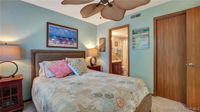 bedroom with carpet, visible vents, a closet, and ensuite bathroom