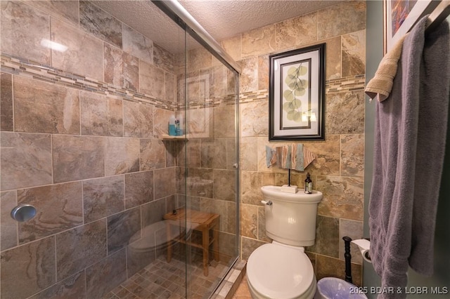 full bath featuring toilet, a stall shower, and a textured ceiling