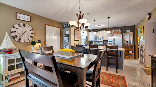 dining space featuring a textured ceiling, light tile patterned flooring, and a notable chandelier