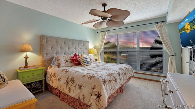 carpeted bedroom with a ceiling fan and a textured ceiling