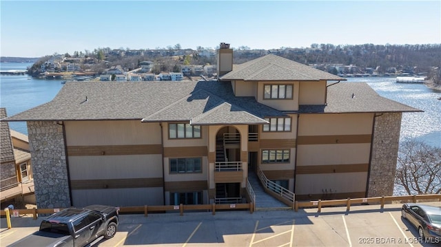 view of building exterior featuring a water view and uncovered parking