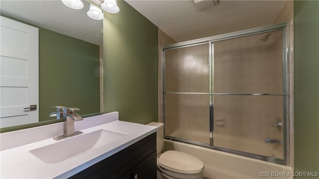 bathroom featuring toilet, shower / bath combination with glass door, and vanity