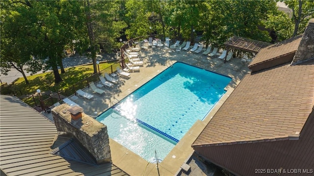 pool with a patio area and fence