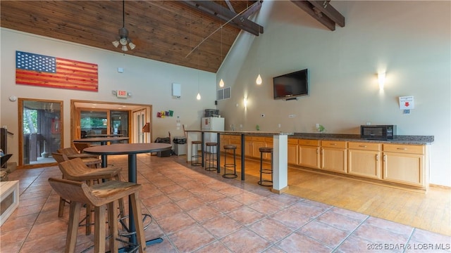 bar featuring black microwave, light tile patterned floors, wooden ceiling, visible vents, and a ceiling fan