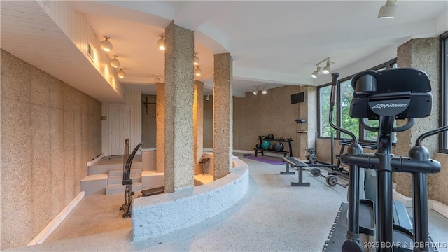 exercise area featuring visible vents, decorative columns, and rail lighting