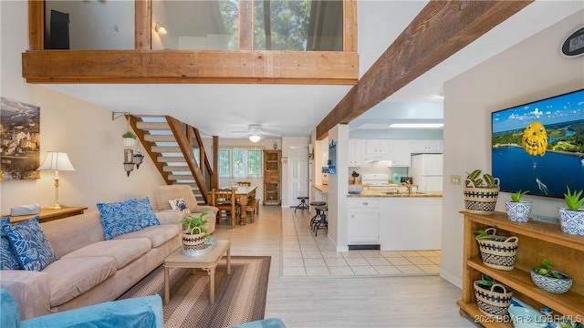 living room with light wood-type flooring, beam ceiling, ceiling fan, and stairs