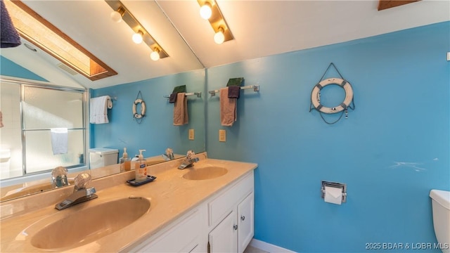 full bath featuring lofted ceiling with skylight, a stall shower, a sink, and toilet