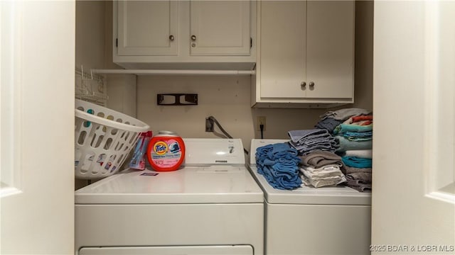 clothes washing area with washing machine and dryer and cabinet space