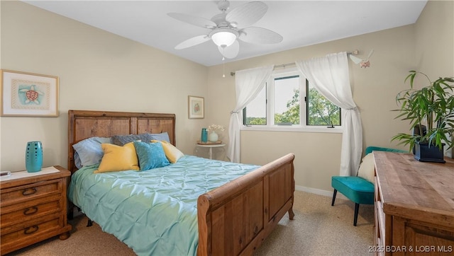 bedroom with ceiling fan, light carpet, and baseboards