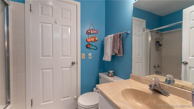 full bath featuring tiled shower, vanity, and toilet