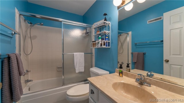 bathroom featuring visible vents, vanity, toilet, and enclosed tub / shower combo