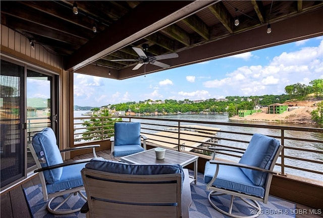 wooden deck with a water view and ceiling fan