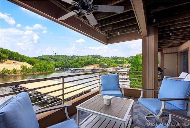 balcony featuring a water view and a ceiling fan