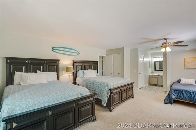 bedroom with light colored carpet, connected bathroom, baseboards, and ceiling fan